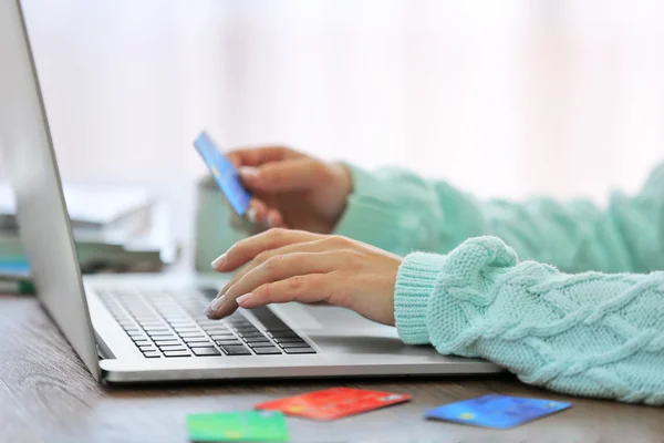 E-commerce concept. Woman with credit card and laptop, close up