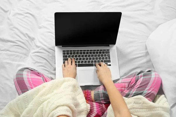Woman in pajamas with laptop