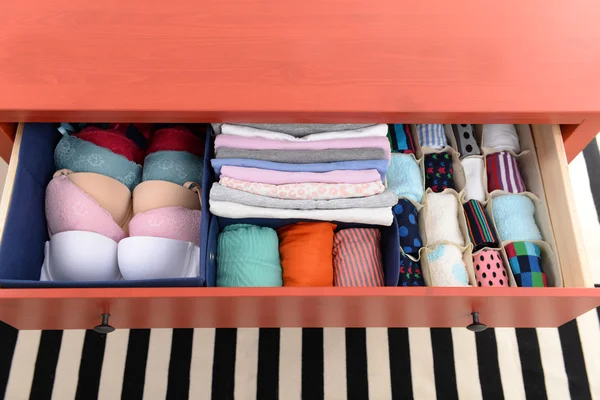 Folded clothes in chest of drawers