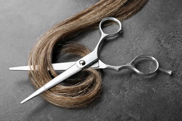 Scissors with strand of brown hair