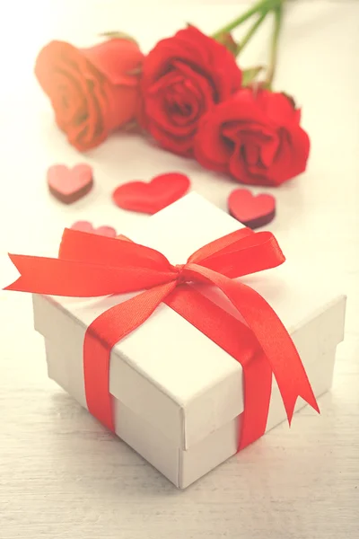 Gift box, rose flowers and decorative hearts