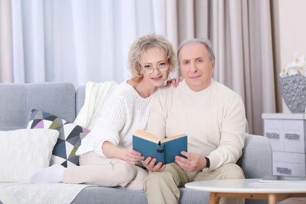 Happy mature couple reading book