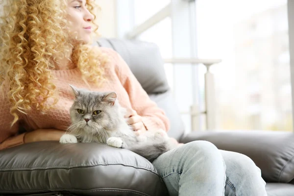 Young woman and cat on sofa