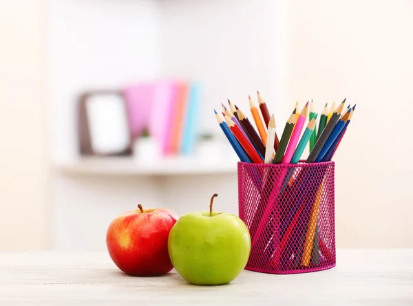 Two apples and organizer with pencils