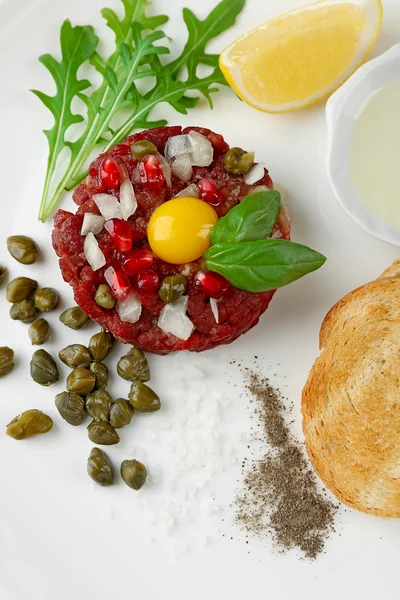 Beef tartare served on a white desk, top view