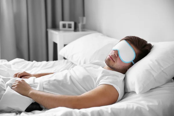 Young man sleeping with blindfold