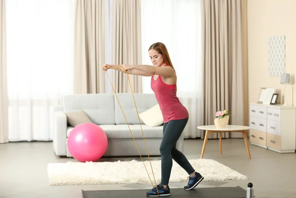 Sportswoman doing exercises with rubber band