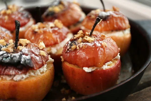 Baked apples with cottage cheese, raisins and walnut in pan, close up