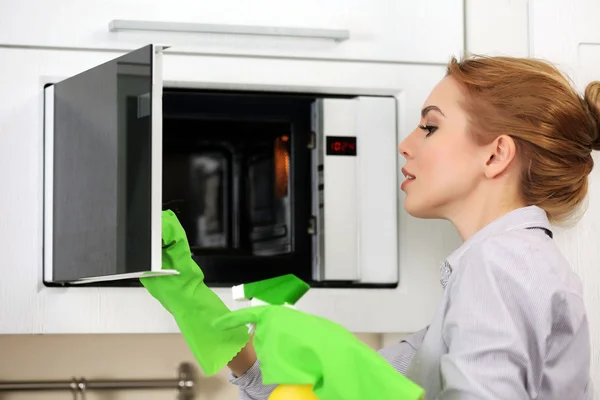 Woman cleaning microwave