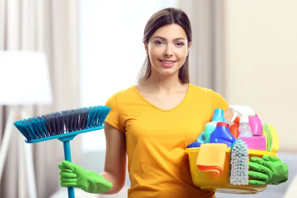 Woman with basin of cleaning supplies