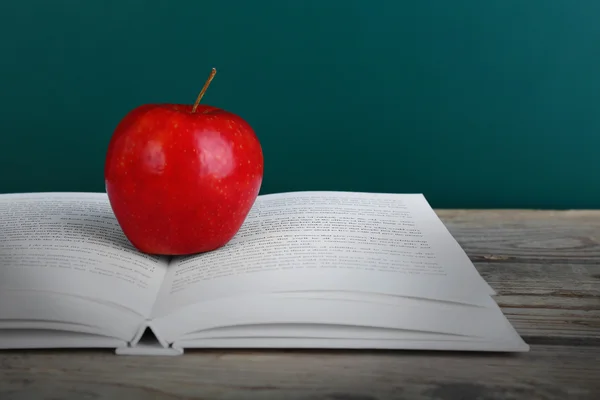 Open book with red apple