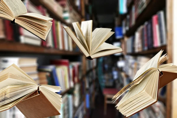 Flying books on library bookshelves background