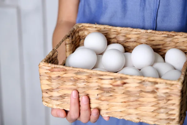 Eggs in basket in woman hands