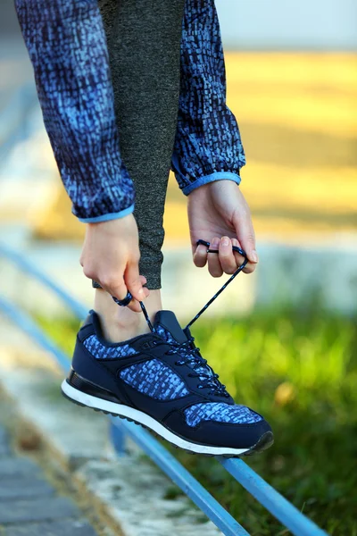 Woman in sportswear tying shoelaces