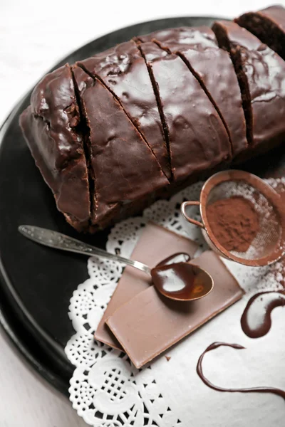 Chocolate sliced cake with icing and cocoa powder