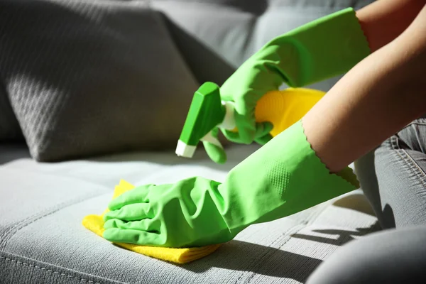 Woman cleans sofa