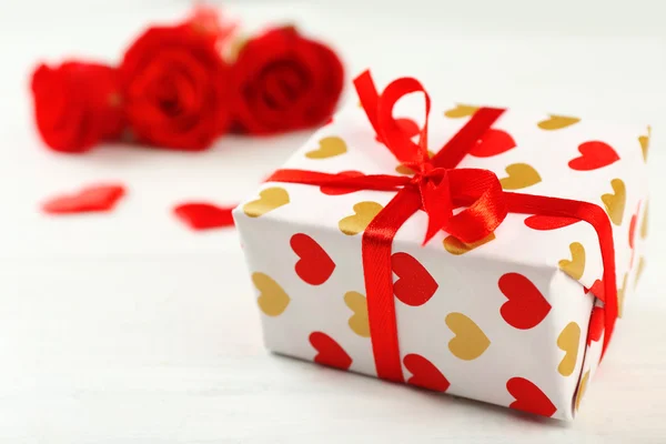 Gift box, rose flowers and decorative hearts