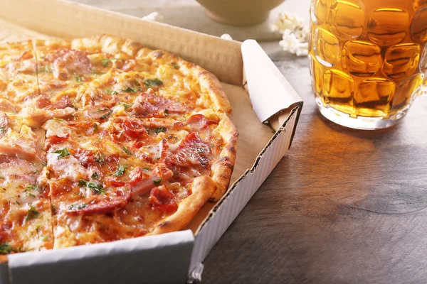 Tasty pizza in carton and glass
