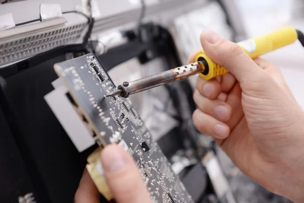 Repairer working with soldering iron