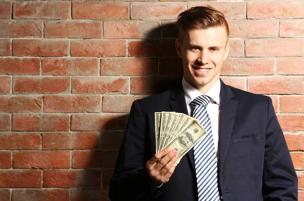 Attractive man holding fan of banknotes