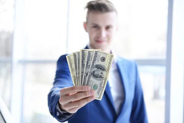 Attractive man holding fan of banknotes