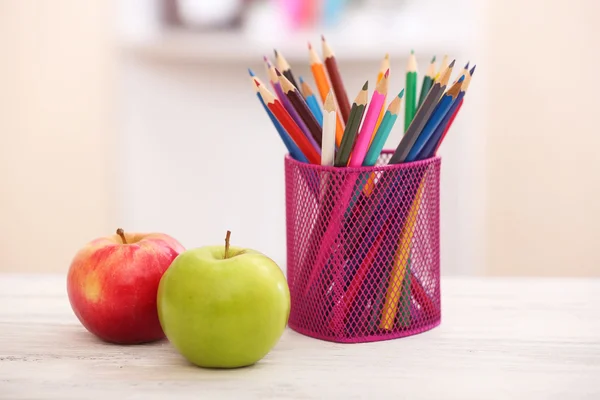 Two apples and organizer with pencils