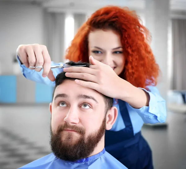 Hairdresser making stylish man haircut