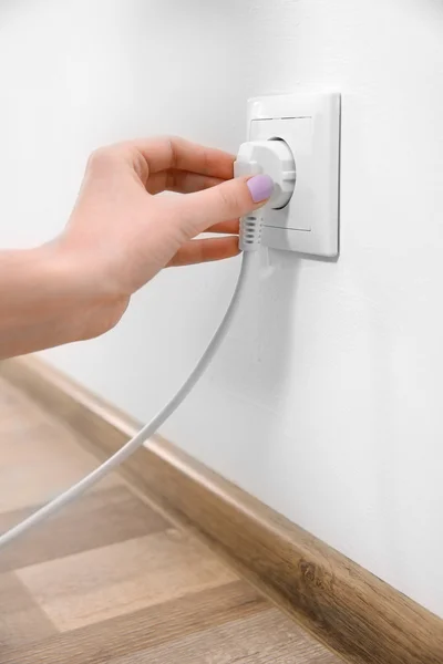 Woman with power outlet and plug