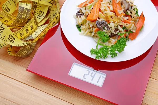 Plate with pilaf on kitchen scales
