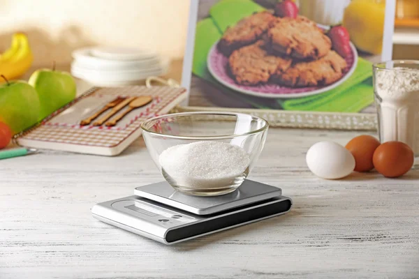 Bowl of sugar and digital kitchen scales