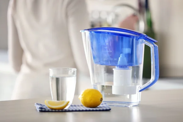 Water filter jug with lemon and glass