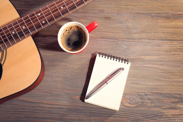 Guitar with notebook and cup of coffee