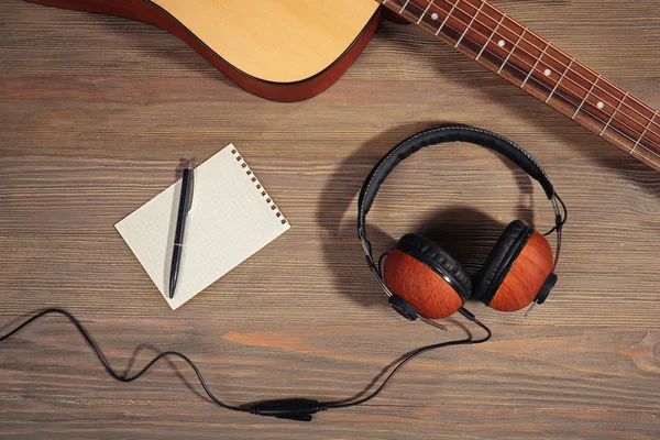 Guitar with headphones and notebook