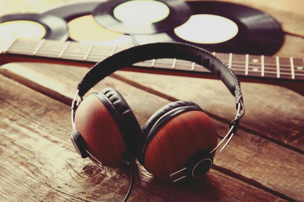 Headphones and guitar on wooden