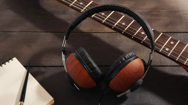 Guitar with headphones and notebook