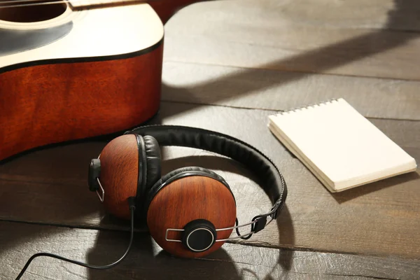 Guitar with headphones and notebook