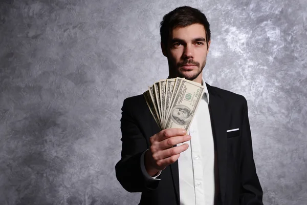 Man in a suit holding dollar banknotes