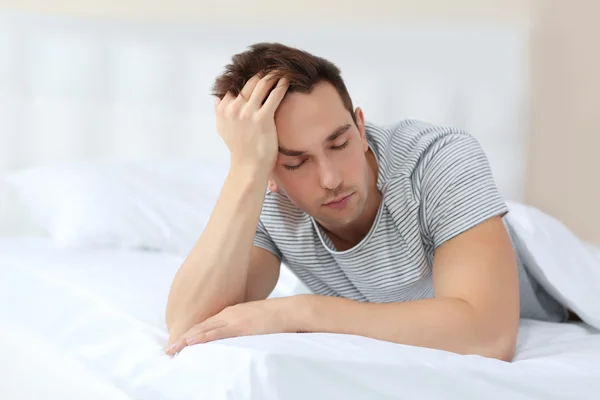 Sleepy young man in bed