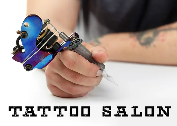 Hand of tattoo artist with tattoo machine