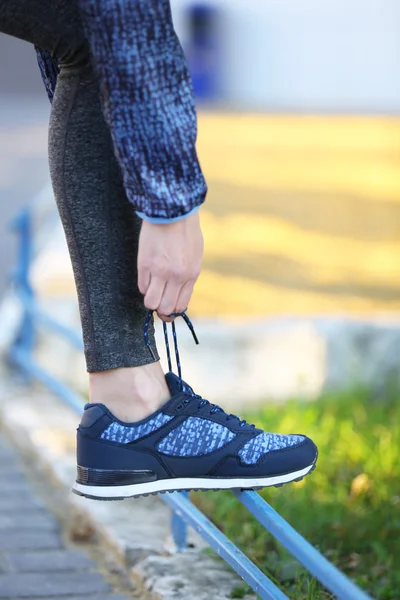 Woman in sportswear tying shoelaces