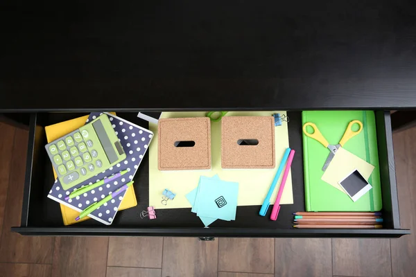 Stationery in open desk drawer