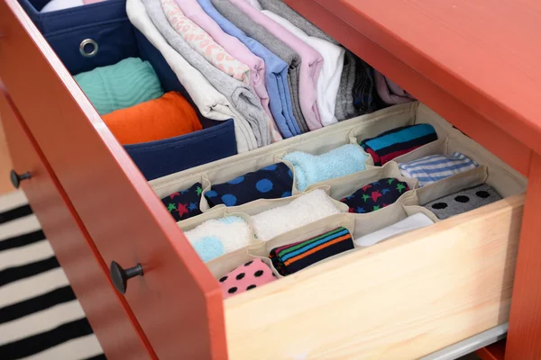 Folded clothes in chest of drawers