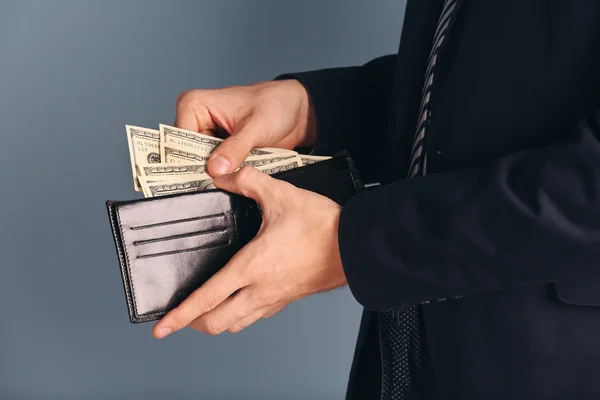Man getting dollar banknotes out of purse