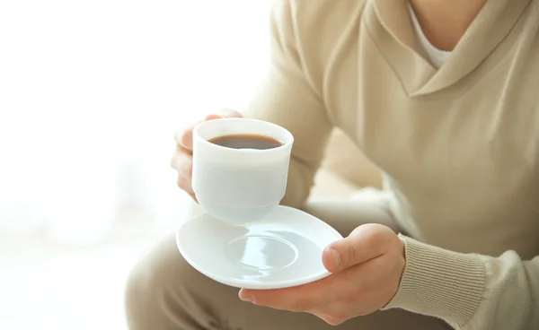Man holding cup of coffee in hands
