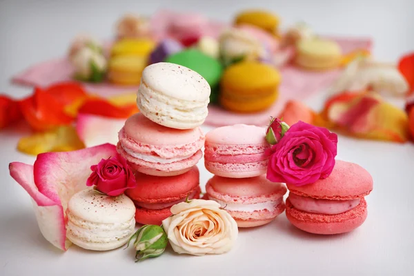 Macaroons with roses on background