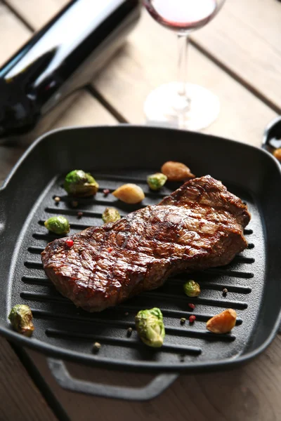 Grilled steak on grill pan with wine