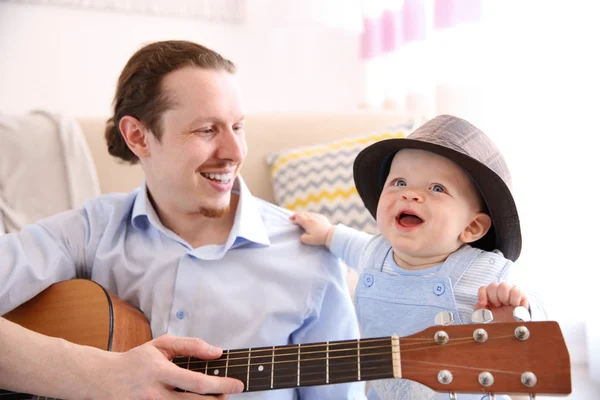 Father playing guitar to son