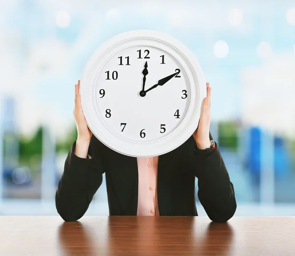 Woman holding big round clock