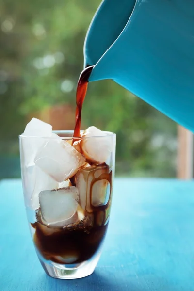 Coffee pouring into glass with ice
