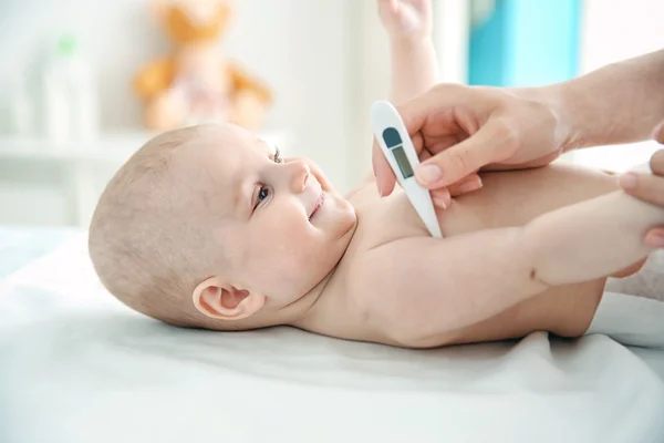 Doctor taking baby\'s temperature